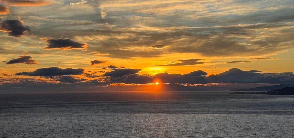 Puesta de sol en La Herradura vista desde Punta de la Mona, tonos dorados sobre la bahía